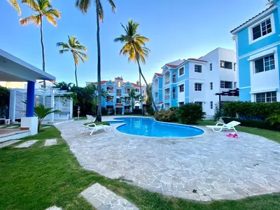 a backyard with a swimming pool and palm trees at Madonna1 pool beach los corales Arenas de Bavaro in Punta Cana