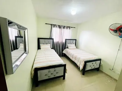 two beds in a small room with a mirror at Oasis de Paz 4 in Jarabacoa