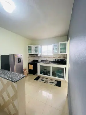a kitchen with white cabinets and a stainless steel refrigerator at Oasis de Paz 4 in Jarabacoa
