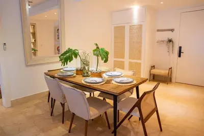 a dining room with a wooden table and chairs at Fortunity Beach Tower-2 BDR with pool view in San Felipe de Puerto Plata