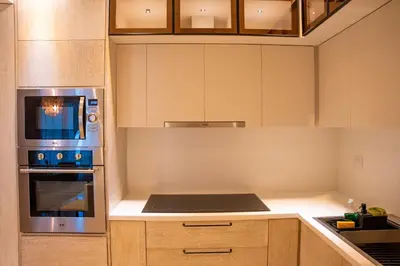 a kitchen with a stove and a microwave at Fortunity Beach Tower-2 BDR with pool view in San Felipe de Puerto Plata