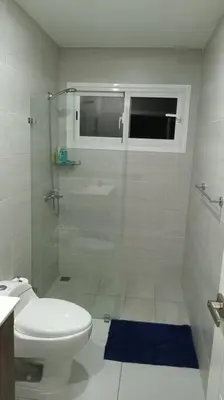 a white bathroom with a shower and a toilet at Confortable apartamento en Playa Nueva Romana in San Pedro de Macorís
