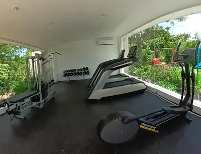 a gym with tread machines and a large window at Confortable apartamento en Playa Nueva Romana in San Pedro de Macorís