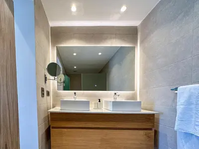 a bathroom with two sinks and a mirror at Fantastic Penthouse at Golf Course in Punta Cana