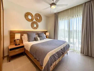 a bedroom with a bed and a large window at Fantastic Penthouse at Golf Course in Punta Cana
