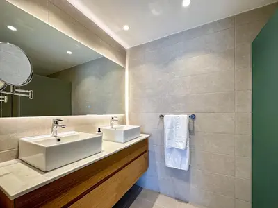 a bathroom with two sinks and a mirror at Fantastic Penthouse at Golf Course in Punta Cana