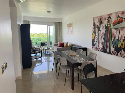 a living room with a table and chairs and a couch at Hard Rock at Cana Rock 3 by Unwind Properties in Punta Cana
