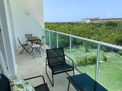 a balcony with chairs and tables and a view at Hard Rock at Cana Rock 3 by Unwind Properties in Punta Cana