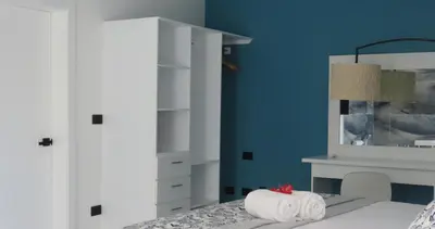 a bedroom with blue walls and a bed with towels at All Seasons Hotel in Bayahibe