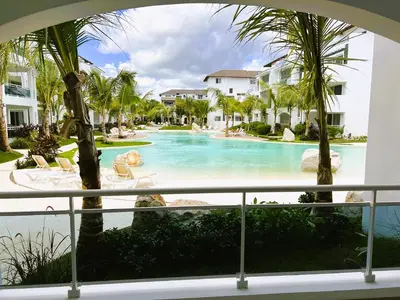a view of a swimming pool with palm trees at Komfortowy Apartament z 4 Basenami i Pięknym Ogrodem, Estrella Dominicus-Bayahibe in Bayahibe