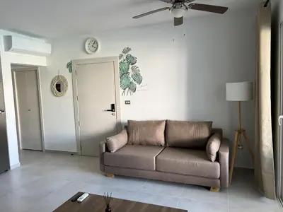a living room with a couch and a ceiling fan at Komfortowy Apartament z 4 Basenami i Pięknym Ogrodem, Estrella Dominicus-Bayahibe in Bayahibe
