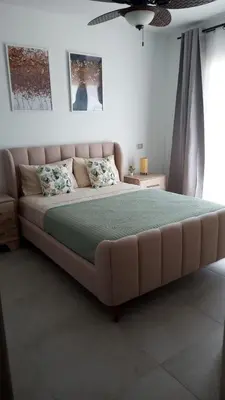a bedroom with a large bed with a green blanket at Komfortowy Apartament z 4 Basenami i Pięknym Ogrodem, Estrella Dominicus-Bayahibe in Bayahibe