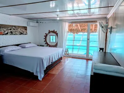 a bedroom with a bed and a table and a window at Dios es Fiel - Ali Hotel in Punta Cana