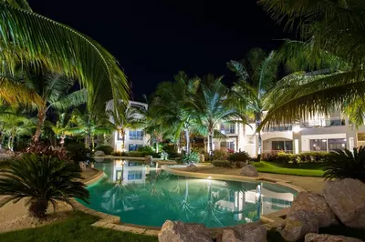 a resort pool at night with palm trees at Star of Caribbean- Estrella Dominicus Bayahibe in Bayahibe