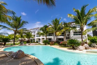 a resort pool with palm trees and a building at Star of Caribbean- Estrella Dominicus Bayahibe in Bayahibe