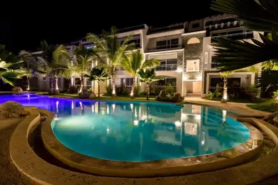 a swimming pool in front of a building at night at Star of Caribbean- Estrella Dominicus Bayahibe in Bayahibe