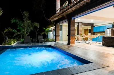 a large blue swimming pool next to a house at Luxury Mountain villa, Jarabacoa villa vargas in Concepción de La Vega