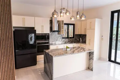 a kitchen with black appliances and a white counter top at Luxury Mountain villa, Jarabacoa villa vargas in Concepción de La Vega