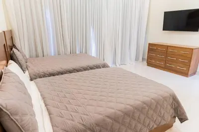 a bedroom with a bed and a dresser with a tv at Luxury Mountain villa, Jarabacoa villa vargas in Concepción de La Vega