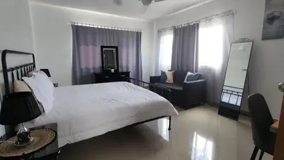 a bedroom with a white bed and a chair at Rooftop with Pool, La Romana, Villa Doña Julia, At Paula Isabel in La Romana