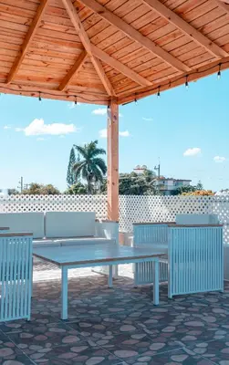 a picnic table and chairs under a wooden pergola at Rooftop with Pool, La Romana, Villa Doña Julia, At Paula Isabel in La Romana