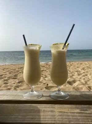 two drinks sitting on a tray on the beach at Las Terrenas Villa- King Bed, Beaches & Dining in Las Terrenas