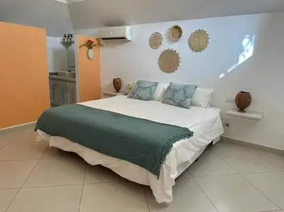 a bedroom with a large white bed with blue pillows at Las Terrenas Villa- King Bed, Beaches & Dining in Las Terrenas