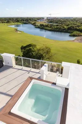 a swimming pool on a deck with a view of a golf course at Modern & relaxing penthouse Lake and Golf View in Punta Cana