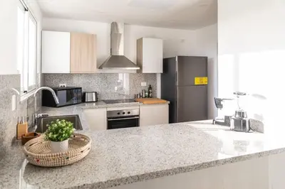 a kitchen with a granite counter top with a sink at Modern & relaxing penthouse Lake and Golf View in Punta Cana