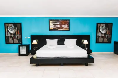 a bedroom with a large bed with a blue wall at Hotel Plaza Brisas in Punta Cana