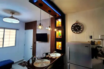 a kitchen with a table and a clock on the wall at Apartamento acogedor Ashmi in Santiago de los Caballeros