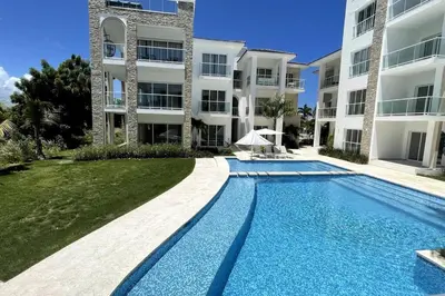 a swimming pool in front of a building at Beautiful Penthouse with private elevator in Hard Rock Golf in Punta Cana