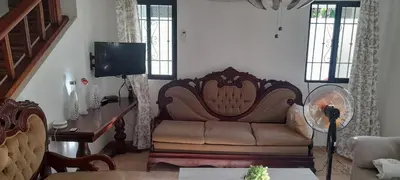 a living room with a couch and a tv at SDQ Villa Isabel, NO FUMAR, cerca embajada EEUU in Santo Domingo