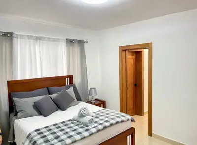 a bedroom with a bed with a black and white checkered blanket at Torre Solarium next to PUCMM in Santiago de los Caballeros