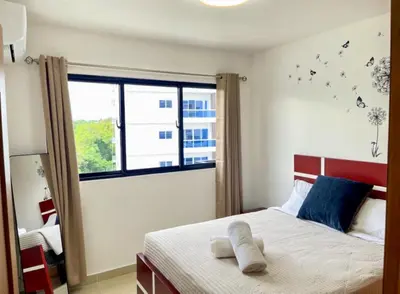 a bedroom with a bed and a large window at Torre Solarium next to PUCMM in Santiago de los Caballeros