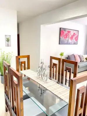 a dining room with a glass table and chairs at Torre Solarium next to PUCMM in Santiago de los Caballeros