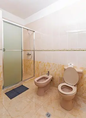 a bathroom with a toilet and a glass shower at Villa Zapata - Apartamentos Turísticos in San Cristóbal