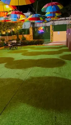 a park with benches and umbrellas on the grass at Villa Zapata - Apartamentos Turísticos in San Cristóbal