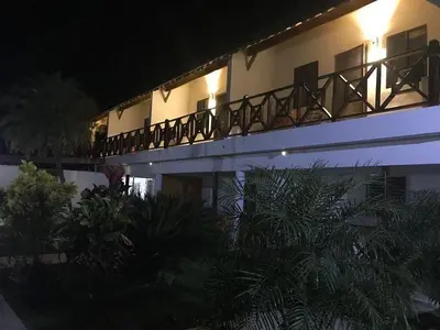 a building with a balcony with trees in front of it at Hotel Piedra Marron in Las Terrenas