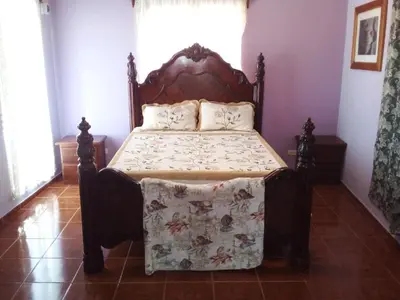 a bedroom with a bed with a wooden headboard at The Beauty of samana in Santa Bárbara de Samaná