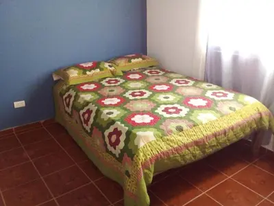 a bed in a room with a bedspread with flowers on it at The Beauty of samana in Santa Bárbara de Samaná
