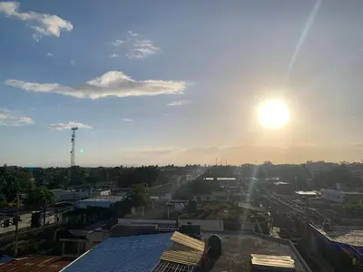 a view of a city with the sun in the sky at Plataview Apartahotel apt 4C in Monte Plata