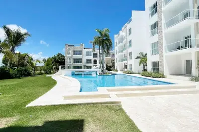 a swimming pool in front of a building at Apartamento de 2 Dormitorios en Hard Rock Golf in Punta Cana