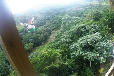 a person flying through the air over a lush green forest at Apartamento de 2 Dormitorios en Hard Rock Golf in Punta Cana