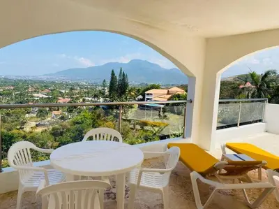 a white table and chairs on a balcony with a view at Heavenly View in San Felipe de Puerto Plata