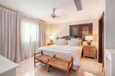 a bedroom with a bed with a bench and a window at Seaside Bliss with pool and spectacular view in Las Minas