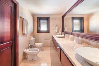 a bathroom with two toilets and two sinks at Seaside Bliss with pool and spectacular view in Las Minas