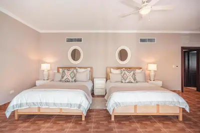 two beds in a room with two mirrors at Seaside Bliss with pool and spectacular view in Las Minas