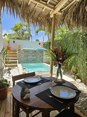 a table with plates and wine glasses on a patio at Casa Shambala B&B in Las Terrenas