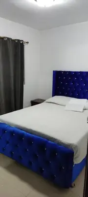 a bed with a blue bed frame in a room at Apartamento acogedor J-A in Los Paredones